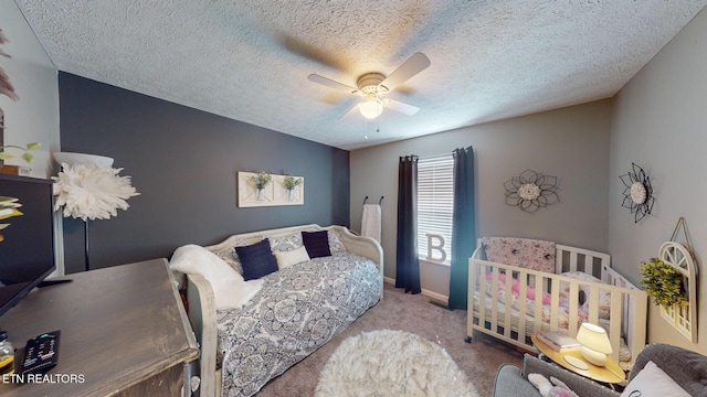 bedroom with ceiling fan, light colored carpet, and a textured ceiling