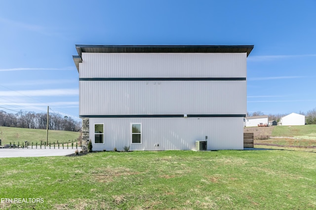 view of home's exterior with cooling unit and a yard