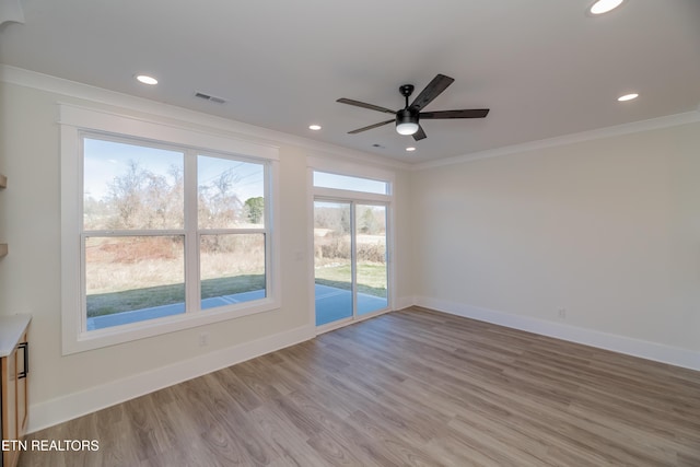 empty room with ornamental molding, ceiling fan, and light hardwood / wood-style flooring