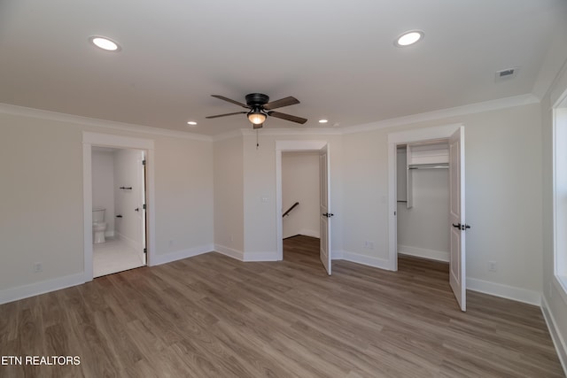 unfurnished bedroom featuring crown molding, connected bathroom, and hardwood / wood-style floors