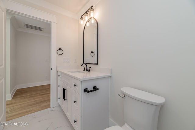 bathroom with vanity, crown molding, and toilet