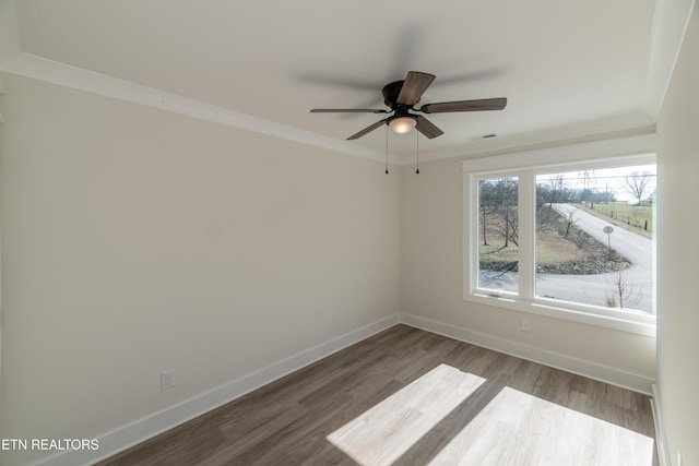 empty room with hardwood / wood-style floors, ornamental molding, and ceiling fan