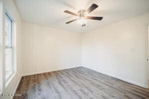 empty room featuring wood-type flooring, ceiling fan, and a healthy amount of sunlight