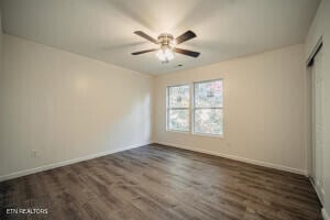 unfurnished bedroom featuring dark hardwood / wood-style floors and ceiling fan