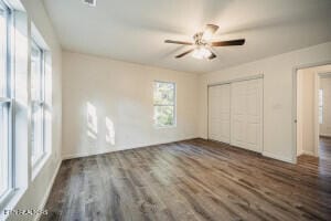 unfurnished bedroom featuring ceiling fan and dark hardwood / wood-style flooring