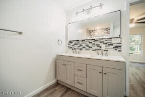 bathroom with decorative backsplash, wood-type flooring, and vanity