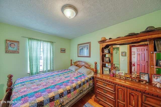 bedroom featuring a textured ceiling and hardwood / wood-style flooring