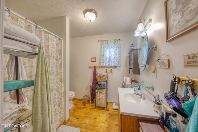 bathroom with vanity, hardwood / wood-style floors, a textured ceiling, and toilet