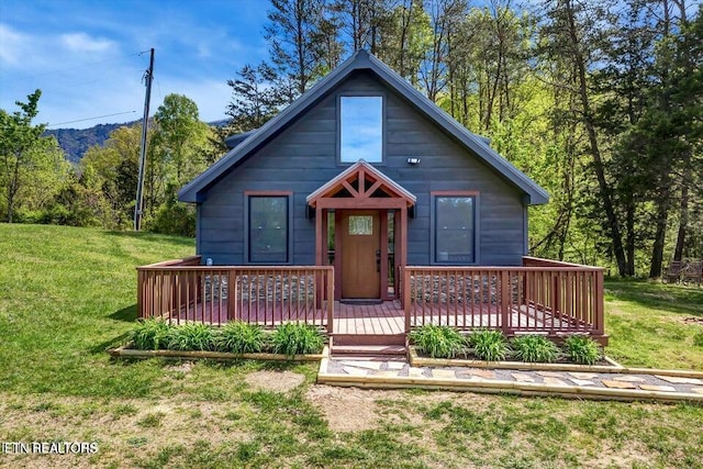 view of front of house featuring a wooden deck and a front lawn