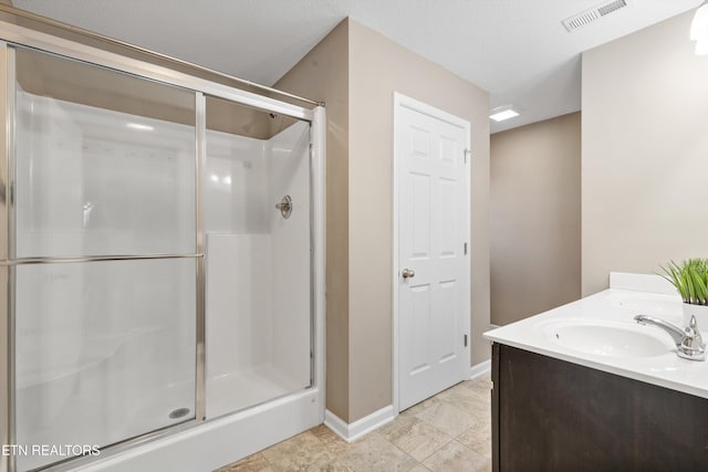 bathroom with vanity and a shower with shower door