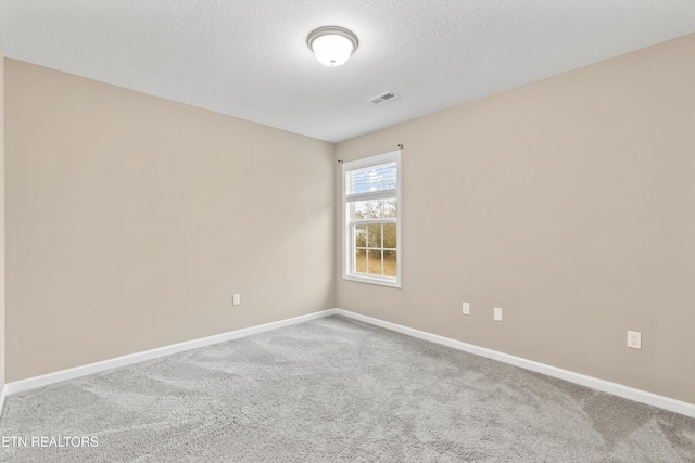 empty room featuring carpet flooring and a textured ceiling