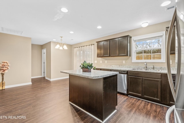 kitchen featuring sink, a center island, hanging light fixtures, dark hardwood / wood-style floors, and stainless steel appliances