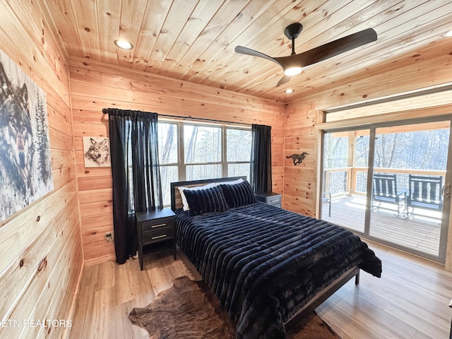 bedroom featuring wooden ceiling, multiple windows, wooden walls, and light wood finished floors