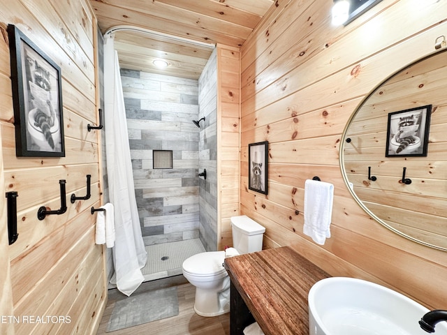 full bath with toilet, a sink, wooden walls, a shower stall, and wooden ceiling