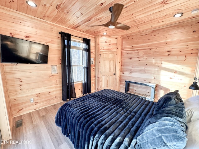 bedroom featuring wooden ceiling, recessed lighting, wooden walls, wood finished floors, and visible vents