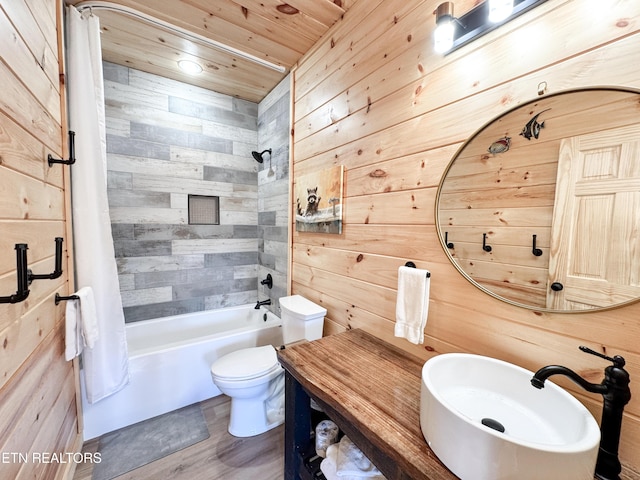 bathroom featuring shower / bath combo, a sink, toilet, and wooden walls