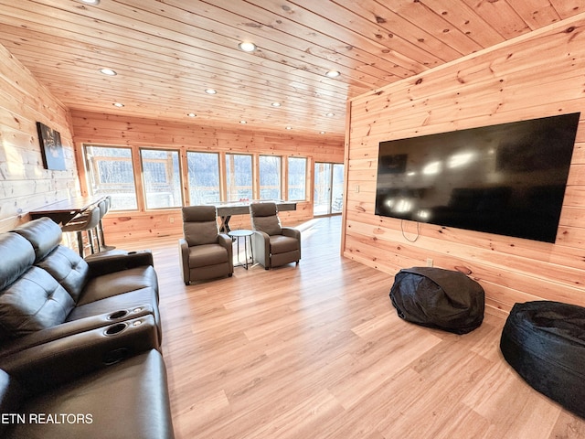 living area with light wood-type flooring, wood ceiling, wooden walls, and a wealth of natural light