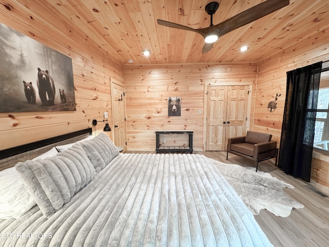 bedroom featuring recessed lighting, wood walls, wooden ceiling, and light wood-style floors