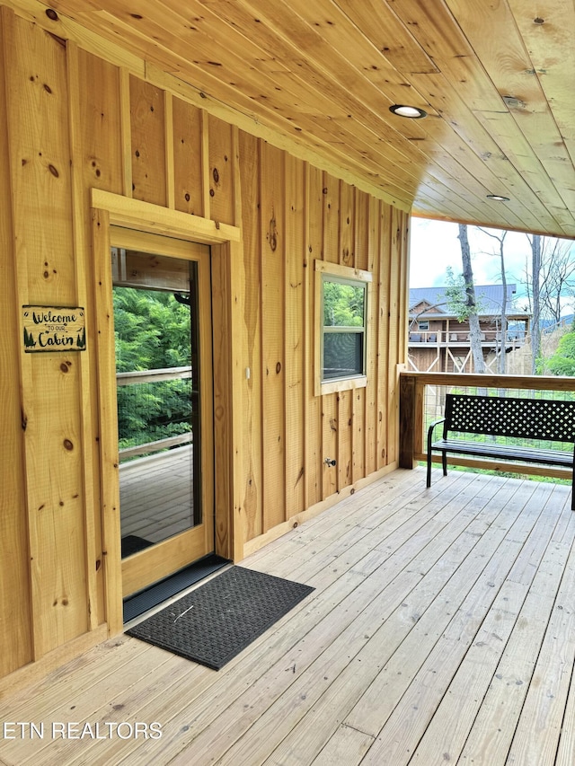 interior space featuring wood ceiling, a healthy amount of sunlight, wood walls, and hardwood / wood-style floors