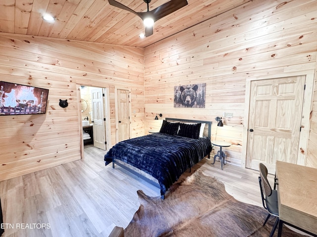 bedroom featuring wooden ceiling, wood finished floors, a ceiling fan, and wooden walls