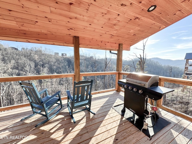 wooden deck with a grill and a mountain view