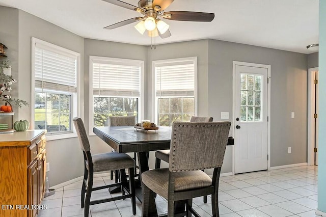 tiled dining room with a wealth of natural light and ceiling fan