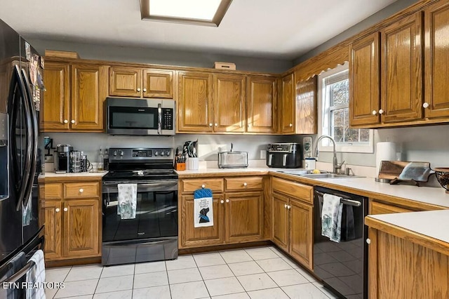 kitchen featuring sink, light tile patterned floors, and black appliances