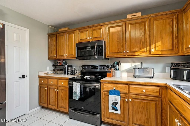 kitchen with light tile patterned floors and stainless steel appliances