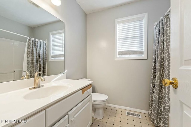 bathroom with walk in shower, vanity, toilet, and a wealth of natural light