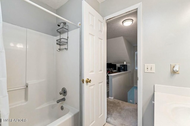 bathroom with vanity, a textured ceiling, and shower / washtub combination