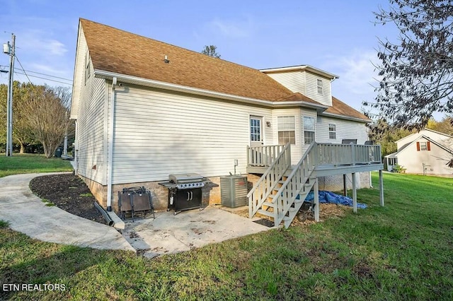 rear view of house featuring a lawn, a wooden deck, cooling unit, and a patio