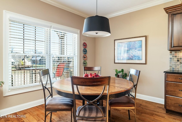 dining space featuring crown molding and wood-type flooring