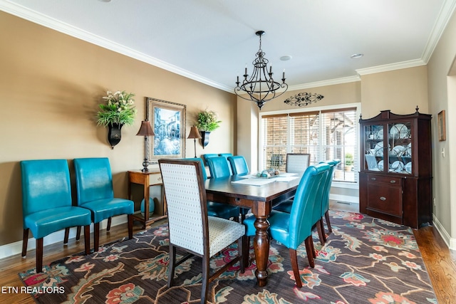 dining space featuring an inviting chandelier, ornamental molding, and dark hardwood / wood-style flooring