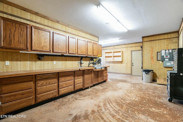 kitchen featuring a textured ceiling and wood walls