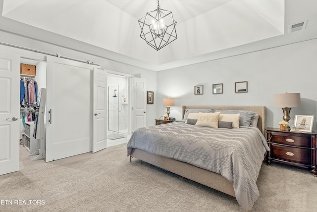 carpeted bedroom with ensuite bath, a spacious closet, a notable chandelier, a towering ceiling, and a closet