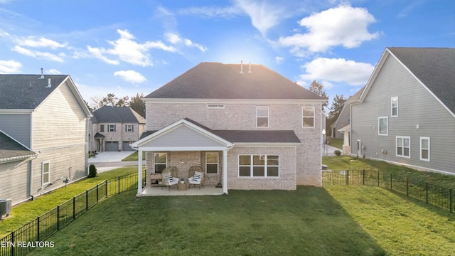 rear view of house featuring a lawn, central AC unit, and a patio