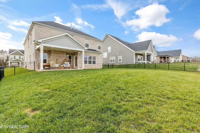 rear view of property featuring a patio area and a lawn