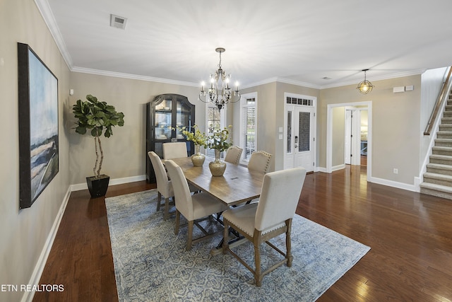 dining room with dark hardwood / wood-style floors, ornamental molding, and a chandelier