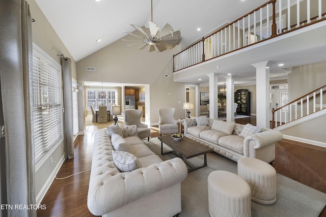 living room featuring ceiling fan, ornate columns, dark wood-type flooring, and high vaulted ceiling