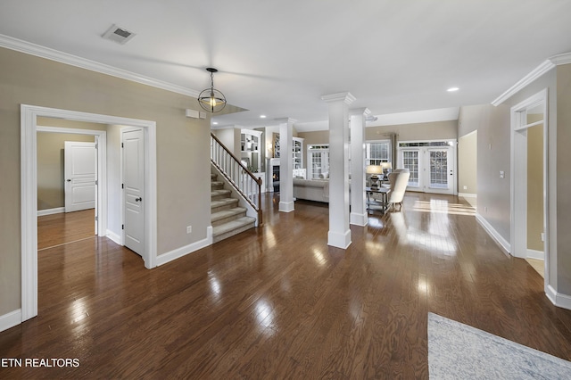 unfurnished living room featuring dark hardwood / wood-style flooring, ornate columns, and crown molding