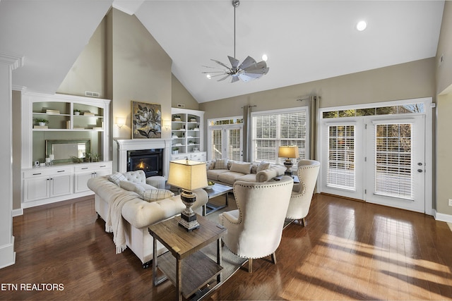 living room with high vaulted ceiling, ceiling fan, and dark wood-type flooring