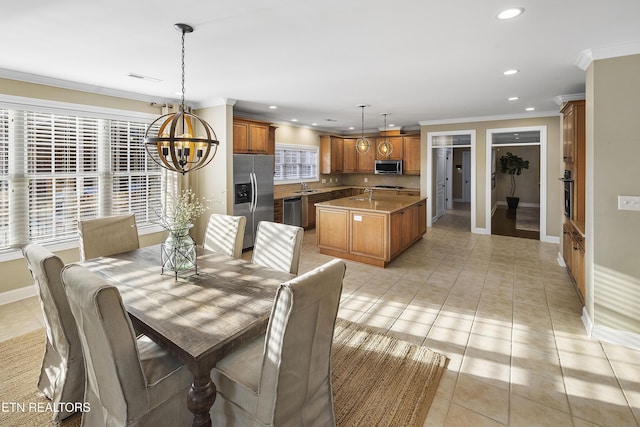 dining area with sink, light tile patterned floors, crown molding, and an inviting chandelier