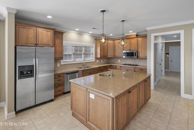 kitchen with a center island with sink, crown molding, sink, appliances with stainless steel finishes, and light stone counters