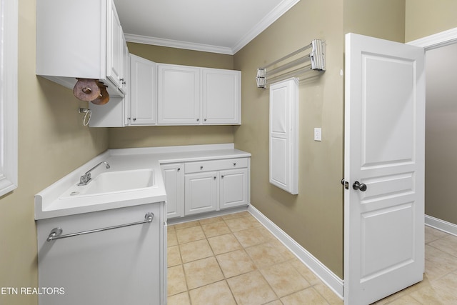 clothes washing area with light tile patterned floors, crown molding, and sink