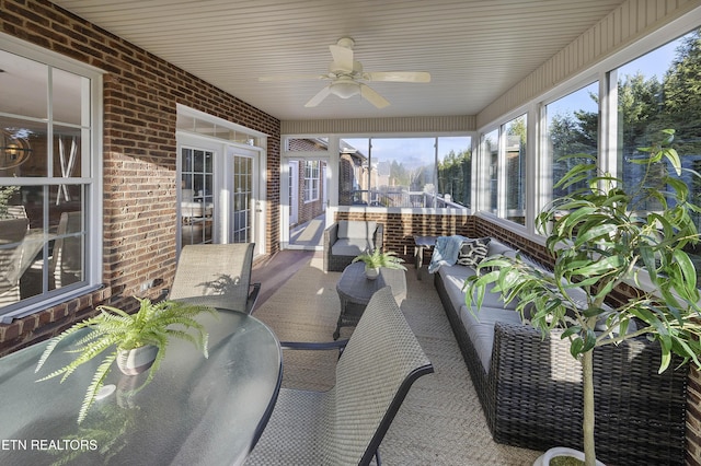 sunroom featuring ceiling fan and french doors