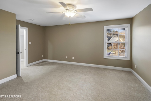 spare room featuring ceiling fan and light carpet