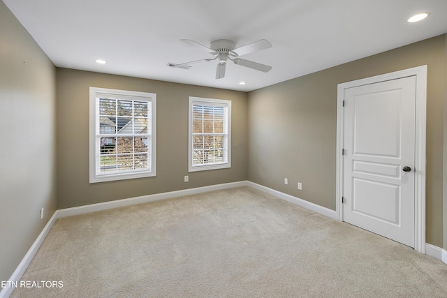 carpeted spare room with ceiling fan