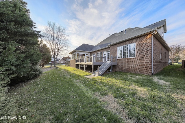 back of property with a lawn and a deck