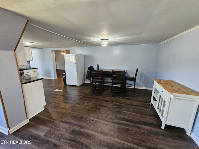 dining area featuring a textured ceiling and dark hardwood / wood-style floors