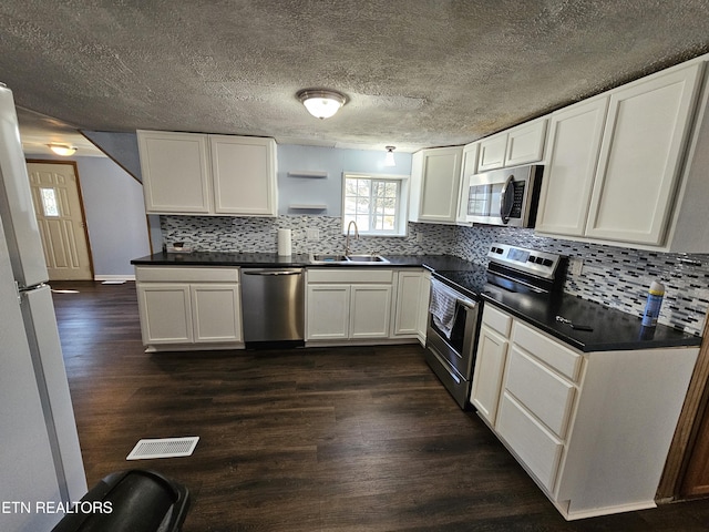 kitchen featuring white cabinets, stainless steel appliances, dark wood-type flooring, and sink